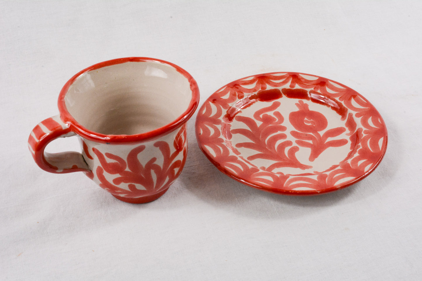Taza de café roja con plato