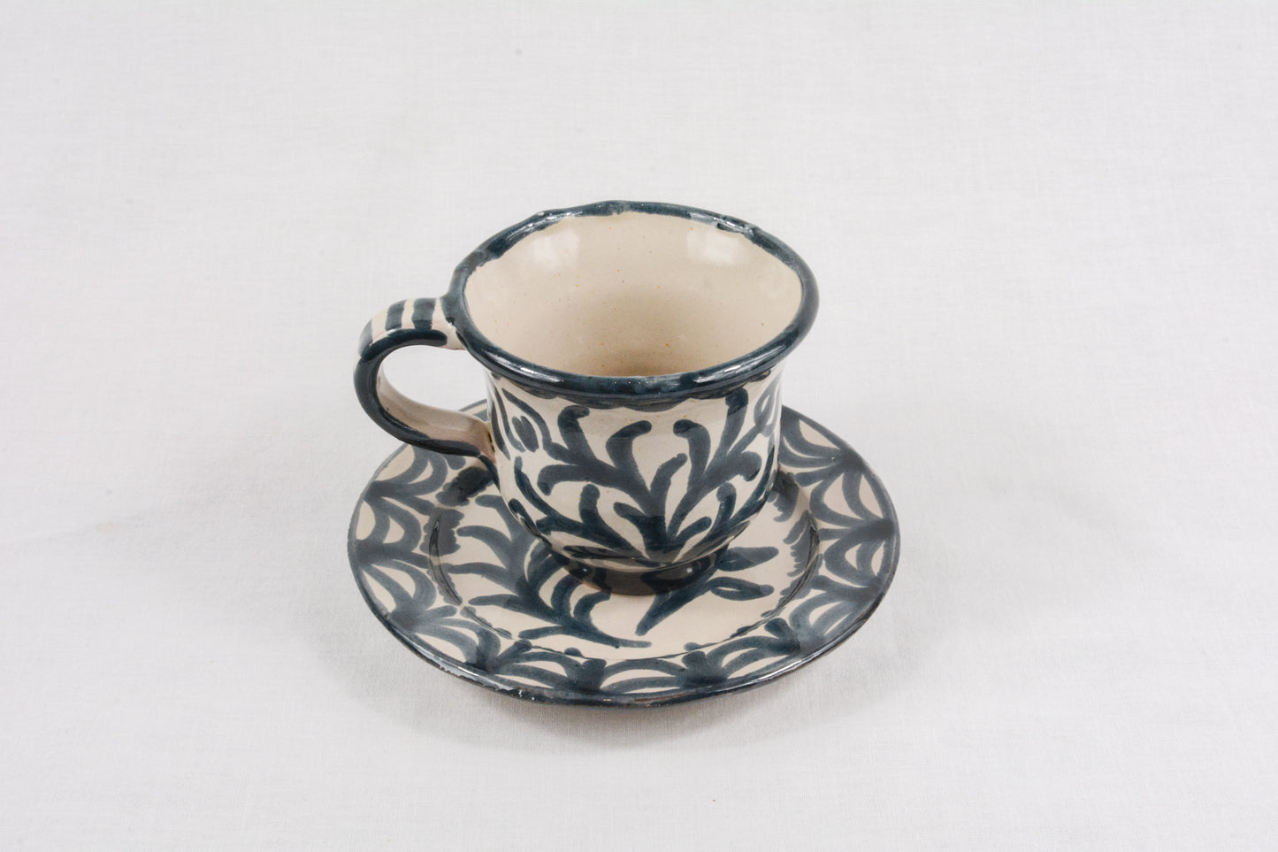 Taza de café azul con plato