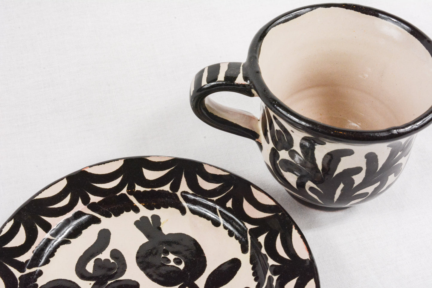 Taza de café con plato negra